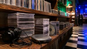 Record store shelf with blank compact discs headphones and checkerboard floor