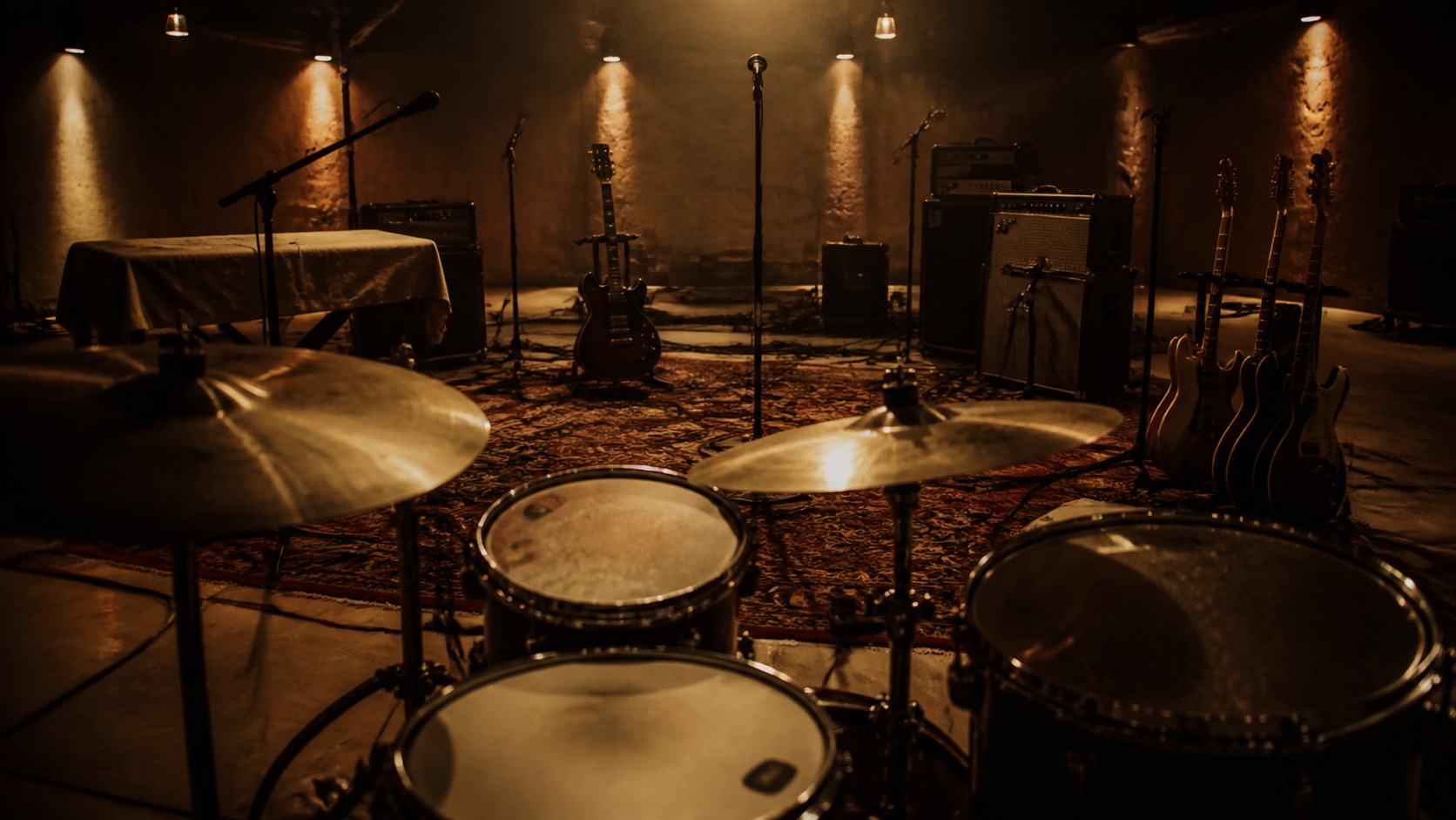 Warm empty rehearsal room with unbranded drums guitars microphones and stage lights